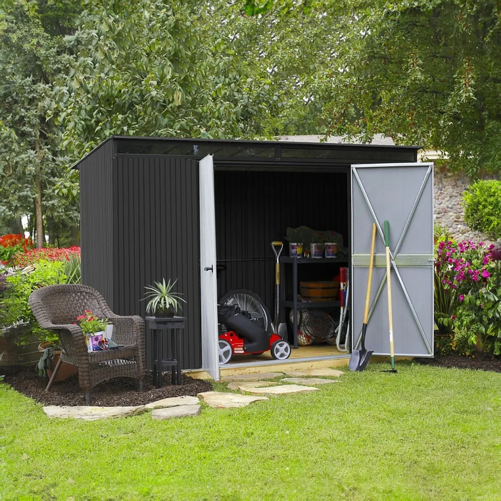 Outdoor garden shed with a galvanized metal roof, open doors revealing gardening tools and supplies, surrounded by lush greenery and flowers