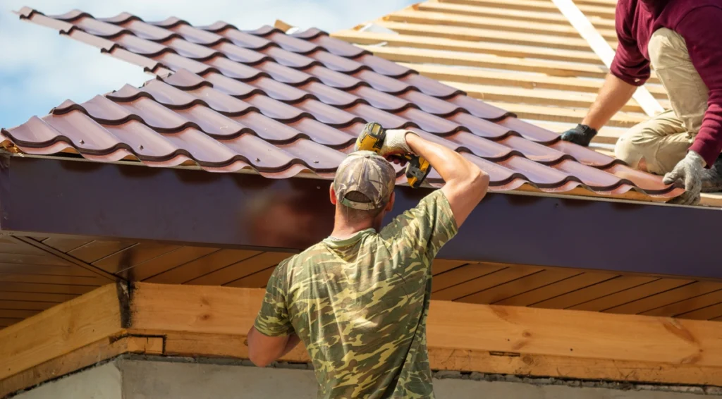 Workers installing a metal shake roof on a wooden frame, showcasing the process of roof construction and durability