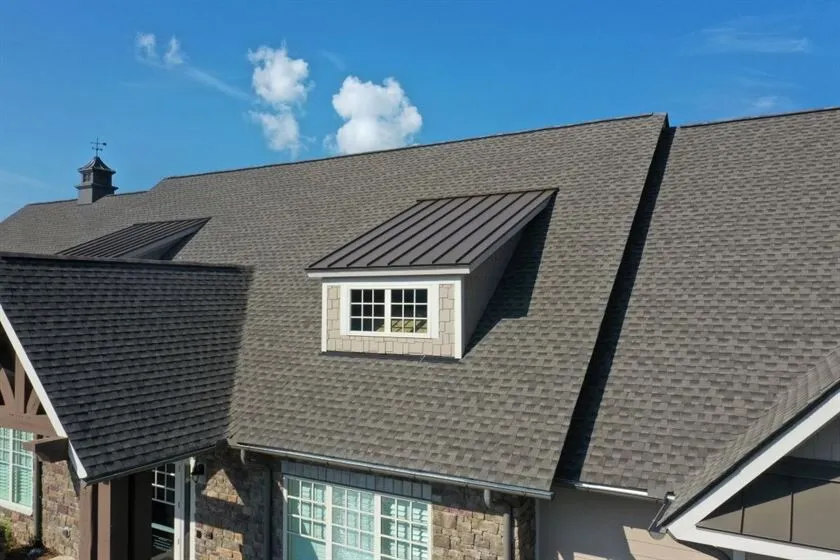 Aerial view of a house with a metal shake roof and a dormer window, highlighting its sleek design and durability against weather conditions