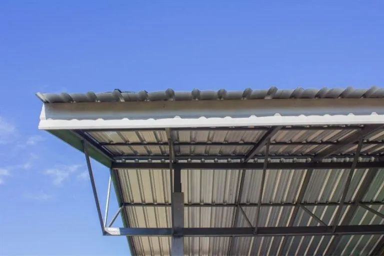 Side view of a steel roof structure under a clear blue sky, highlighting its strength and industrial design