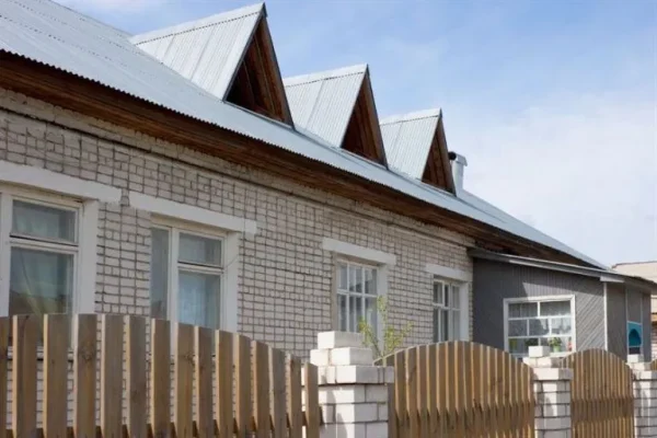 Residential building with a corrugated metal roof, showcasing standard panel widths and a clean, durable design, ideal for weather resistance and longevity.