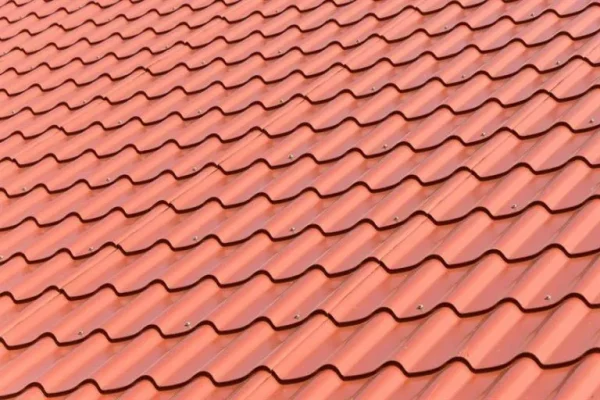 Close-up view of a red tin roof with a wavy tile pattern, showcasing its aesthetic appeal and weather-resistant design